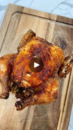 a piece of chicken on a cutting board with a video player in the middle of it