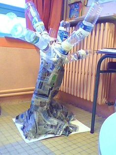 a tree made out of newspapers and water bottles