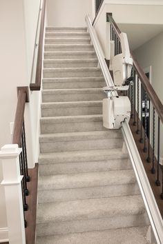 there is a stair lift on top of the carpeted stairs