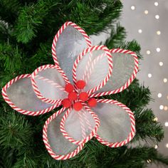 an ornament made out of candy canes on top of a christmas tree