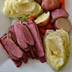 corned beef, cabbage, potatoes and carrots on a white plate with lettuce