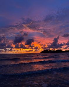 the sun is setting over the ocean with clouds in the sky and water below it