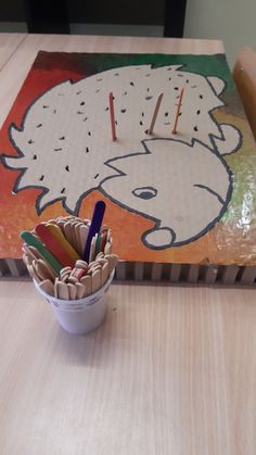 a cup with pencils in it sitting on top of a table