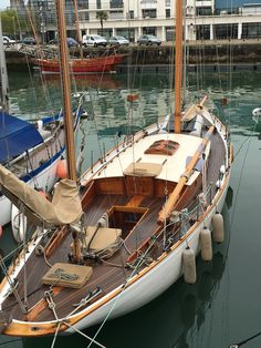 a sailboat is docked in the water near other boats