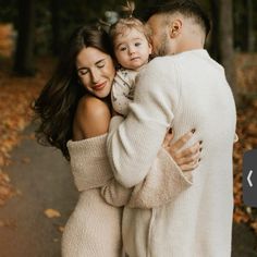 a man and woman holding a small child in their arms