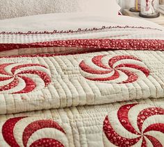 two red and white bedspreads sitting next to each other