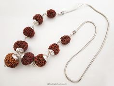 Navgrah Rudraksha Beads Kantha Mala- (Siddha mala) is a Powerful and unique Rudraksha Navagraha Kantha. This Navgrah Rudraksha Beads Kantha consists of Rudrakshas from 2 Mukhi to 9 mukhi (1 each) + 12 Mukhi. There is a silver chain attached to the pendant. This Siddh Mala Silver Pendant appease all the negative planets and gives power to benefic planets. Navgarh Rudraksha kantha is the one pendant, which should definitely be worn by everyone. It does not have any negative effect. It would defini Spiritual Silver Beaded Necklaces For Puja, Spiritual Necklaces With Silver Beads For Puja, Traditional Necklaces With Silver Beads For Meditation, Rudraksha Pendant, Rudraksha Jewelry, 9 Planets, Rudraksha Beads, Silver Caps, Mala Necklace