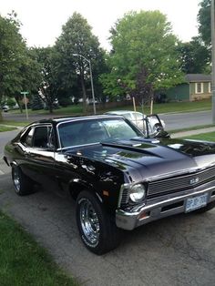 an old black car parked on the side of the road