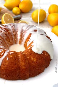 a bundt cake with icing and lemons in the background