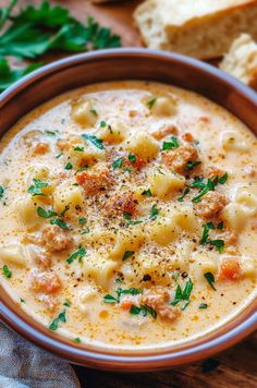 a bowl of pasta soup with bread and parsley on the side, ready to be eaten