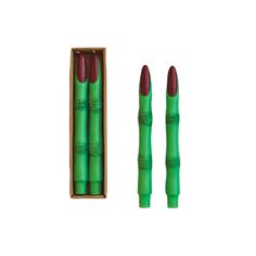 three green and red pens in a box