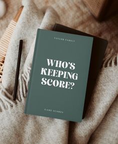 a book that says who's keeping score? on top of a blanket next to a comb