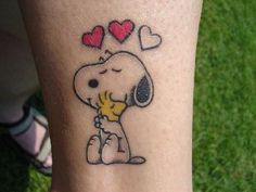 a person with a small tattoo on their leg that has a dog and hearts on it