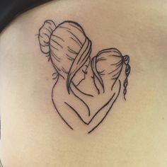 a woman's back with a tattoo of two women hugging and kissing each other