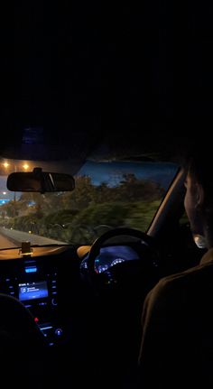 two people driving in the dark on a highway at night