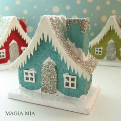 three small houses are decorated with glitter and snow