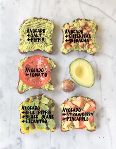 four avocado toasts with different types of toppings on them sitting on a marble surface