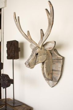 a wooden deer head mounted to the side of a wall