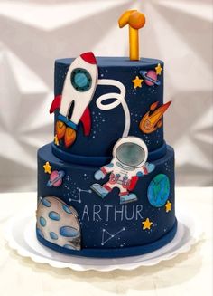 a blue cake with an astronaut theme on it