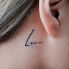 a woman's left ear has a small tattoo on it