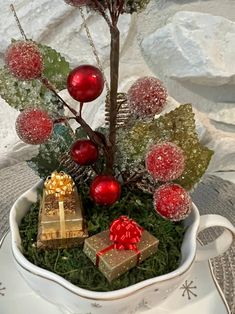 a white bowl filled with christmas decorations on top of a table