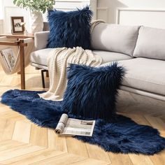 a living room filled with furniture and pillows on top of a hard wood floor covered in blue fur