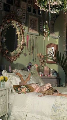 a woman laying on a bed in a room with lots of flowers and plants hanging from the ceiling