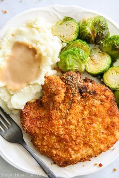 a plate with fried chicken, mashed potatoes and brussel sprouts