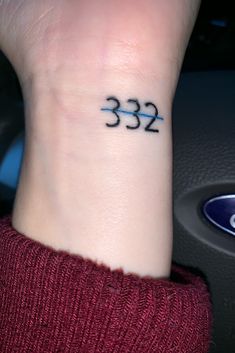 a woman's wrist tattoo with the number 532 on it