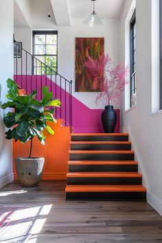 an orange and black stair case next to a potted plant