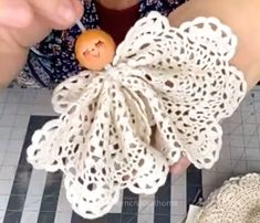 a woman is holding an orange with a face on it