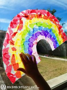 someone holding up a paper plate with a rainbow on it