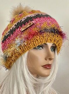 a mannequin head wearing a multicolored hat with fur pom - pom