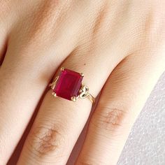 Gold and simulated red Ruby ring.   Ring is made with 9 carat yellow gold.  Simulated red Ruby is Emerald cut and measures 10mmsx8mms. Ring size is L (Australian size) or 5 1/2 (US size). Ring is ready to ship in 1-2 working days.  We resize free of charge.  Please allow a couple of additional days for resizing. This ring can be custom made to your specification.  Contact us with your queries. All my rings come in a velvet ring box. Classic Ruby Ring With Diamond Cut, Classic Lab-created Ruby Ring With Diamond Cut, Classic Ring With Prong-set Lab-created Ruby, Classic Gold Rings With Ruby, Formal Lab-created Ruby Ring With Diamond Cut, Classic Ruby Ring With Diamond Cut For Promise, Classic Diamond Cut Ruby Promise Ring, Red Sapphire Birthstone Ring In 14k Gold, Fine Jewelry Lab-created Ruby Ring With Diamond Cut