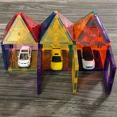 three plastic houses with cars parked in them