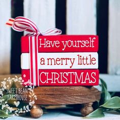 a red and white christmas sign sitting on top of a wooden table