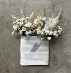 a bouquet of white flowers in an envelope