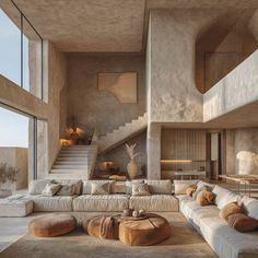 a living room filled with lots of furniture next to a stair case on the wall