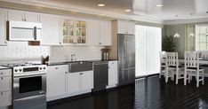 a large kitchen with white cabinets and black floors