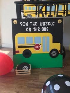 there is a sign that says don the wheels on the bus next to some balloons