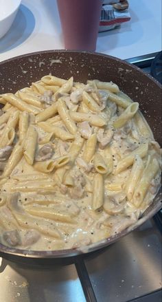 a pan filled with pasta and sauce on top of a stove