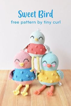 three crocheted birds sitting next to each other on top of a wooden table