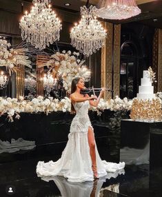 a woman in a white dress standing next to a cake