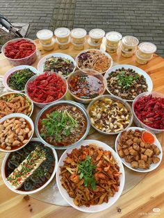 a table topped with lots of bowls filled with different types of food and drinks next to each other