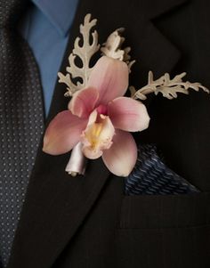 a man wearing a suit and tie with a flower on it's lapel