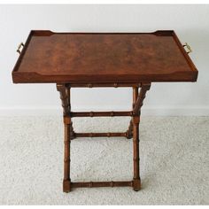 a wooden table with two trays on each side and one sitting on the floor