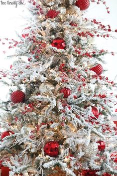 a white christmas tree with red and silver ornaments