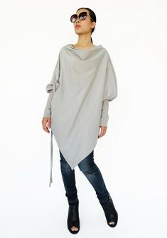 "🚚..ALL ORDERS ARE SHIPPED VIA DHL EXPRESS MAIL This batwing tunic is a very \"cool\" addition to any wardrobe! With a unique drawstrings on bottom hem of tunic provide plenty of options for changing the look. Cowl neckline, batwing sleeves with wide cuffed and oversized side pocket; can be worn layered over leggings, pants, or skirt for even more dramatic effects. * Pull-on style * Cowl neckline * Dropped shoulders * Long sleeves with wide ribbed cuff * Oversize side pocket * Asymmetrical hem Minimalist Clothing, Trendy Sweater, Trendy Sweaters, Womens Sweaters, Cowl Neck Long Sleeve, Hem Sweater, Cowl Neckline, Sweater Pullover, Asymmetrical Hem