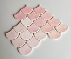 pink scallop tiles are arranged in the shape of a fish's tail