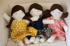 three dolls are sitting on a white couch with their arms around each other as if they were holding hands